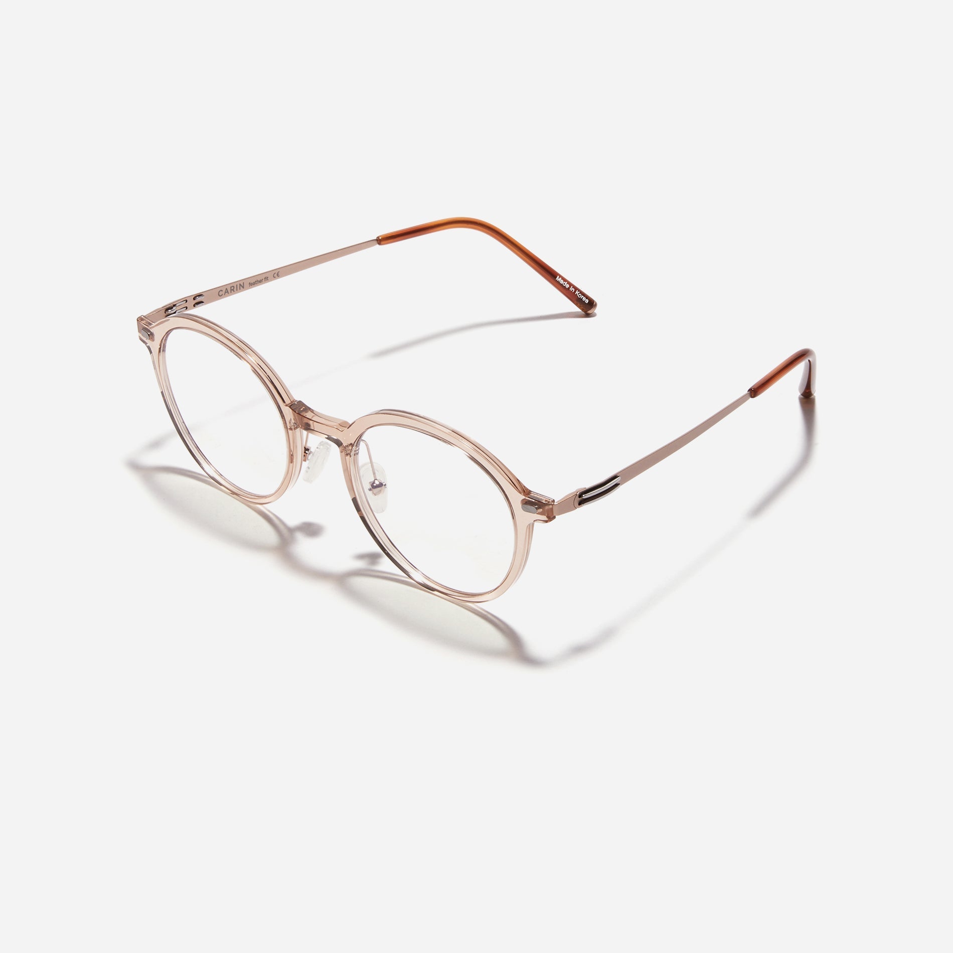 Round-shaped combination eyeglasses from CARIN's 'Feather Fit' line. Their combination frame seamlessly blends bio-plastic and titanium, utilizing advanced injection molding technology, often seen in the manufacturing of cell phones and watches.