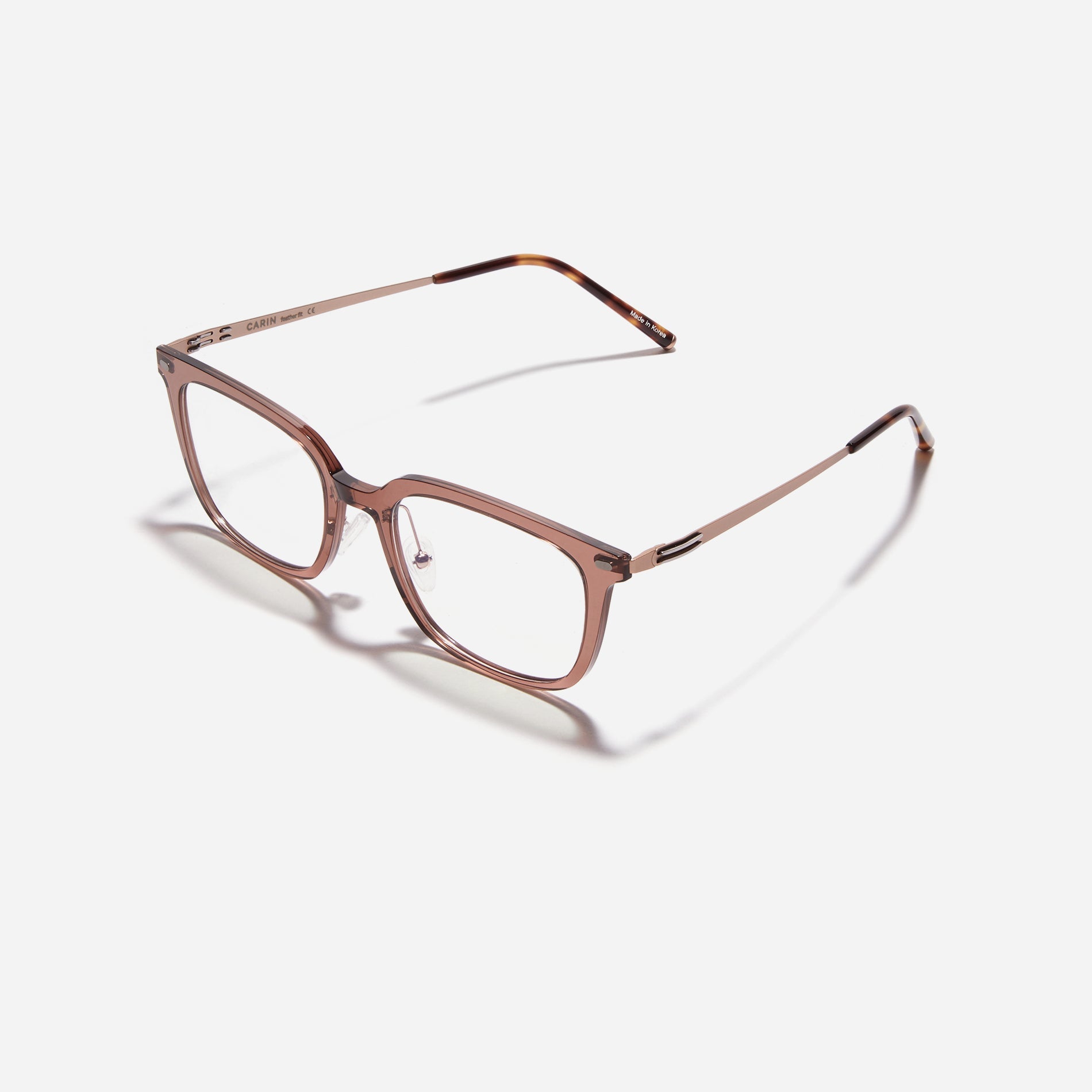 Square-shaped combination eyeglasses from CARIN's 'Feather Fit' line. Their combination frame seamlessly blends bio-plastic and titanium, utilizing advanced injection molding technology, often seen in the manufacturing of cell phones and watches.