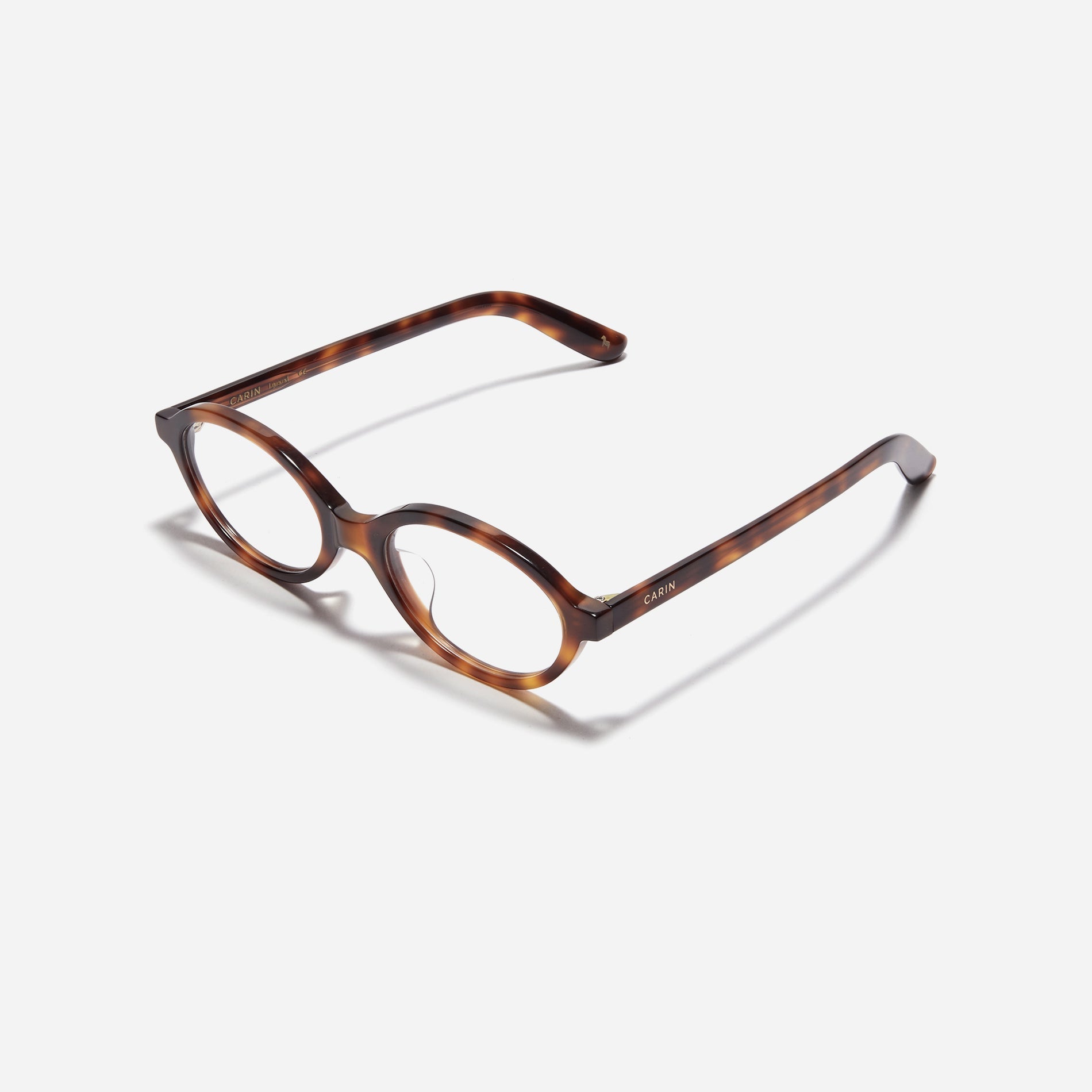 Compact, oval-shaped horn-rimmed eyeglasses featuring a narrow rim and bold frame. Their design captures a modern reinterpretation of 90s retro vibes, providing a trendy and stylish look.