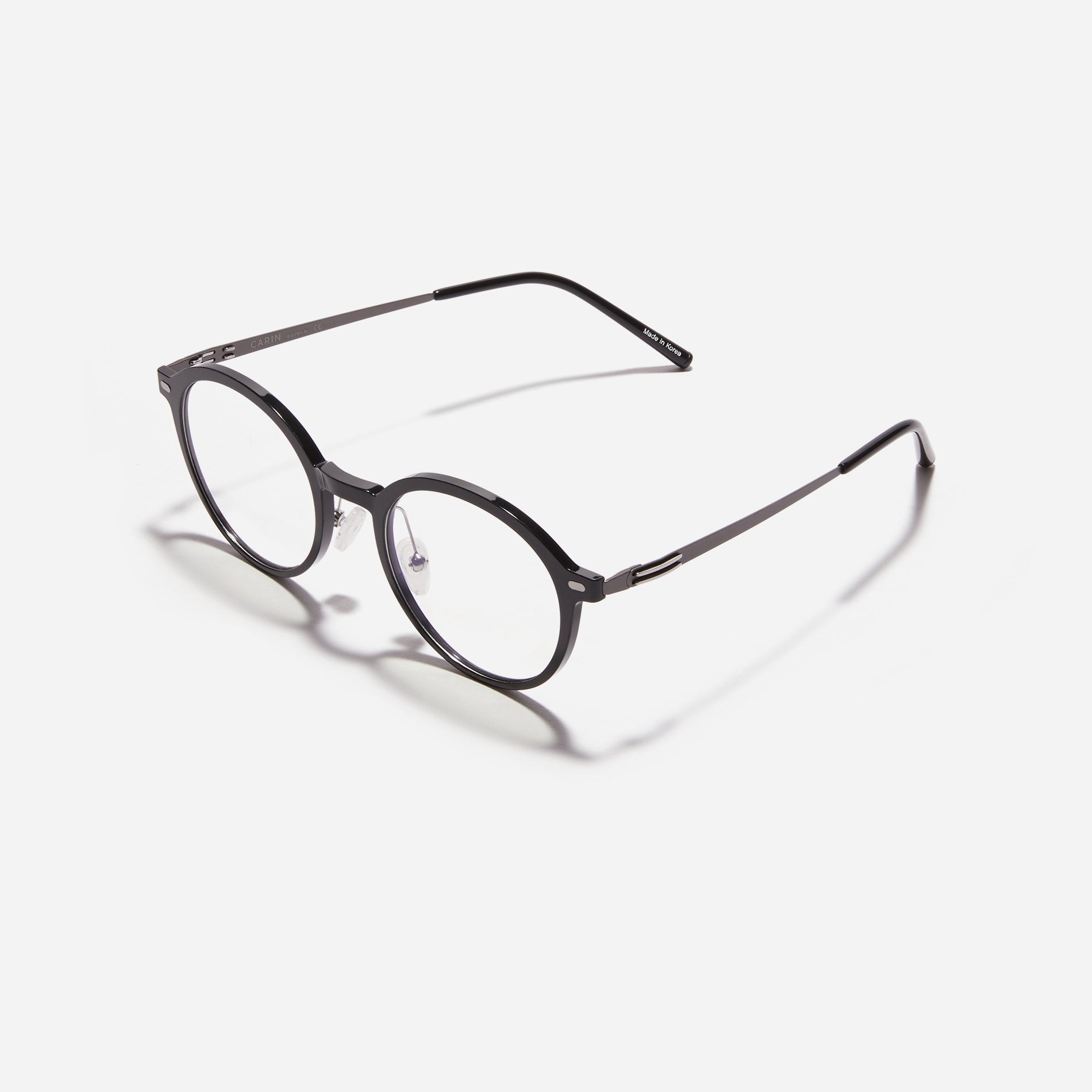 Round-shaped combination eyeglasses from CARIN's 'Feather Fit' line. Their combination frame seamlessly blends bio-plastic and titanium, utilizing advanced injection molding technology, often seen in the manufacturing of cell phones and watches.
